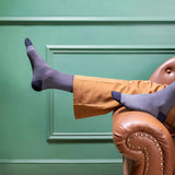 An image of beige patterned formal socks worn with brown leather dress shoes and dark trousers.