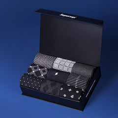Supersox premium gift box containing six pairs of men’s dress socks in black and grey tones with subtle patterns.